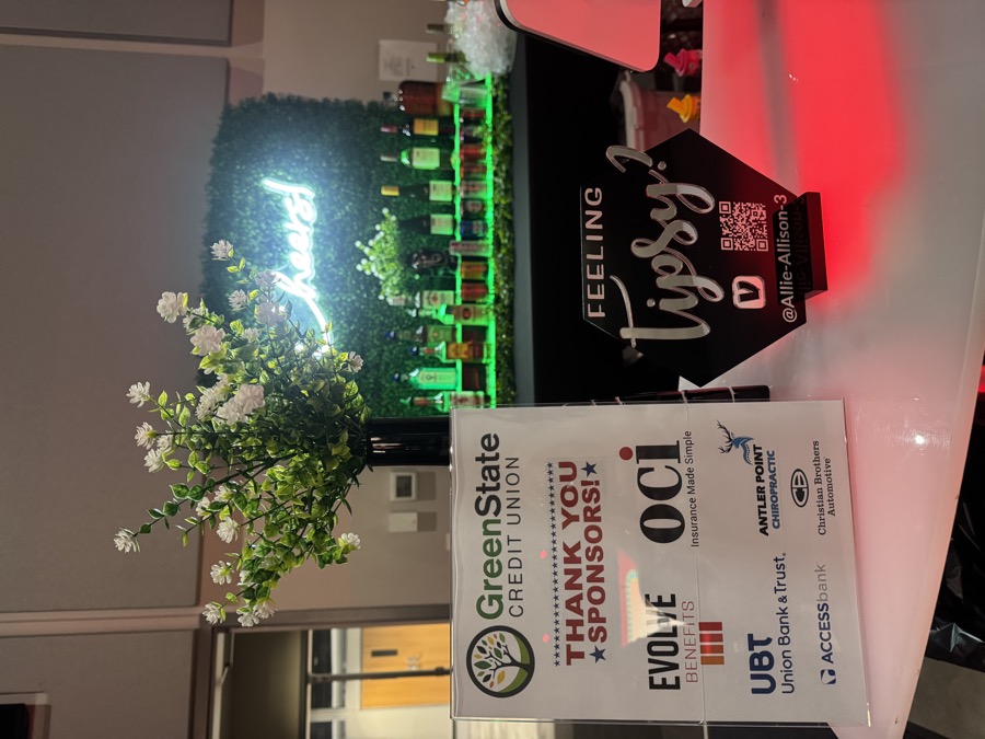 Cheers neon-lit bar setup at a corporate sponsor appreciation event with thank-you sign
