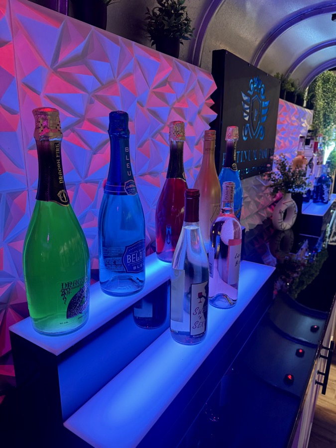 Premium bottle display on Jackpot's LED-lit interior shelves bathed in pink and blue light