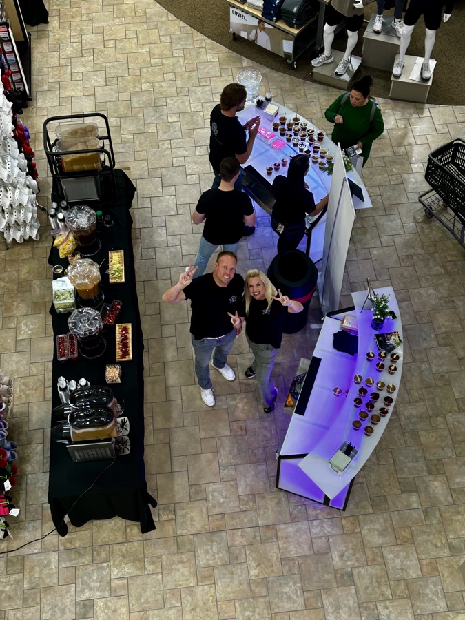 Overhead view of guests mingling around the Platinum Pours bar setup with cocktail tables